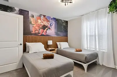 a bedroom with two beds and a painting of mickey mouse at Casa Disney | Piscina Privativa no Storey Lake in Kissimmee