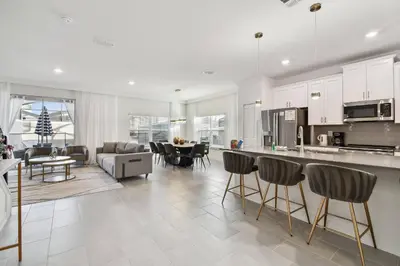 a kitchen and living room with a counter and chairs at Casa Disney | Piscina Privativa no Storey Lake in Kissimmee