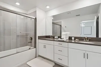 a white bathroom with a shower and a sink at Casa Disney | Piscina Privativa no Storey Lake in Kissimmee