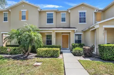a house with a palm tree in the front yard at 2BR Villa Near Disney, Gated community with Pool in Kissimmee