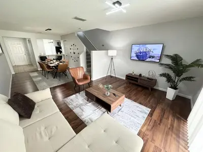 a living room with a white couch and a table at 2BR Villa Near Disney, Gated community with Pool in Kissimmee