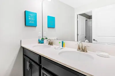 a bathroom with two sinks and a large mirror at Casa Familiar no Storey Lake c/ Piscina in Kissimmee