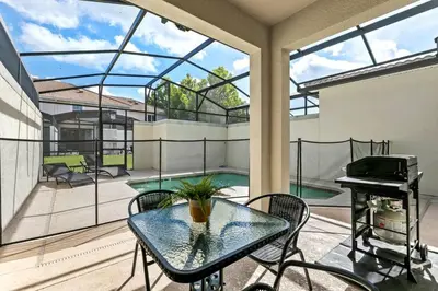 a patio with a glass table and a piano at Casa Familiar no Storey Lake c/ Piscina in Kissimmee