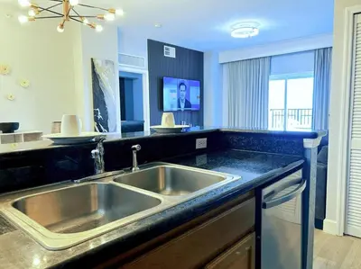 a kitchen with a stainless steel sink and black counter top at Resort Lake Buena Vista - 2 Quartos in Orlando