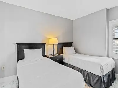 two beds in a room with white walls at Apartamento Aconchegante no Enclave Suites in Orlando