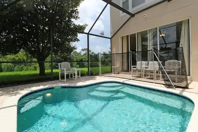 a swimming pool in front of a house at The Orlando Hideaway Family Townhome Steps from Disney 3BR 3BA in Kissimmee