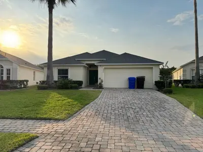 a house with a palm tree and a driveway at Casablanca Villa home in Kissimmee