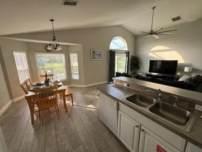 a kitchen and dining room with a table and a sink at Casablanca Villa home in Kissimmee