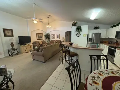 a kitchen and living room with a couch and a table at Cumbrian Sunset Villa home in Kissimmee