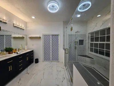 a white bathroom with a shower and a sink at Charming, beautiful house closer to Disney World in Orlando