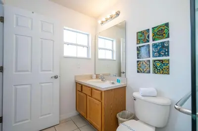 a bathroom with a toilet and a sink and a mirror at Bright 3B w Pool Close to Disney Encantada 8545 in Kissimmee