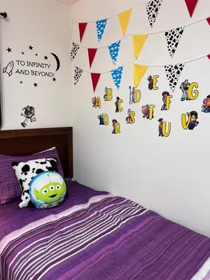 a bedroom with a purple bed with a wall with flags at Toy Story Getaway Retreat in Kissimmee