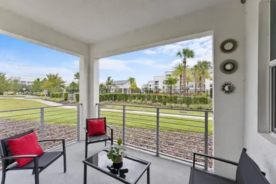 a balcony with two chairs and a table and a view at 3120-102 Resort Pool View Disney Universal Orlando in Kissimmee