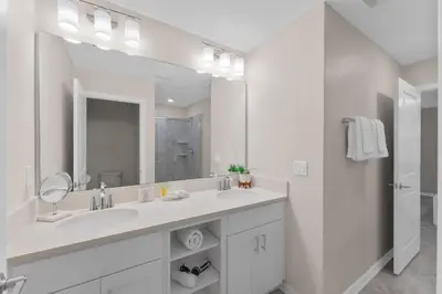 a white bathroom with a sink and a mirror at 3120-102 Resort Pool View Disney Universal Orlando in Kissimmee