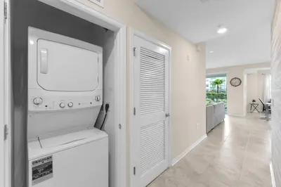a living room with a tv and a hallway at 3120-102 Resort Pool View Disney Universal Orlando in Kissimmee