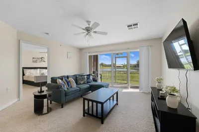 a living room with a couch and a tv at Spacious 2BR Condo Near Disney with Pool & Basketball in Kissimmee