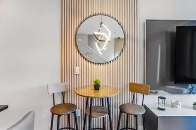 a table and stools in a room with a mirror at 3 Bedroom 8 Miles from Disney Word in Kissimmee