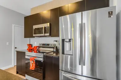 a kitchen with a stainless steel refrigerator and a stove at 3 Bedroom 8 Miles from Disney Word in Kissimmee