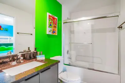 a green bathroom with a sink and a shower at 3 Bedroom 8 Miles from Disney Word in Kissimmee