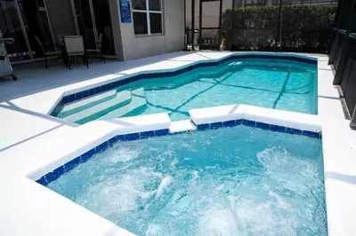 a large pool with blue water in a yard at Game Room 4 BD Private Pool BBQ 2252 in Kissimmee