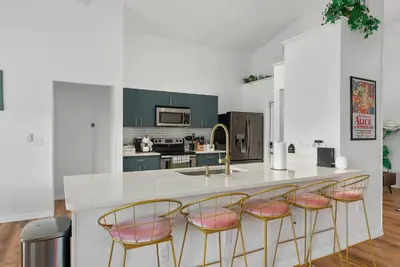 a kitchen with a counter with four chairs around it at [Popular Illusion Home] •Waterfront Private Pool in Kissimmee