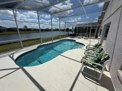 a swimming pool on a house with two chairs and a swimming poolvisorangeringktop at Ortega Villa home in Kissimmee