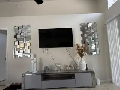 a living room with a tv on a wall at 3 bedroom home with private pool in Orlando