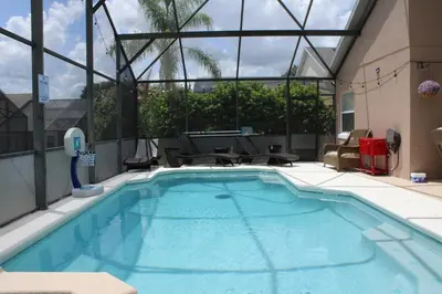 a swimming pool in a building with a large window at Cozy family house near Disney,epic and universal in Orlando