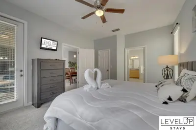 two swans sitting on a white bed in a bedroom at Disney Getaway Pool Gated Resort Near Parks in Kissimmee