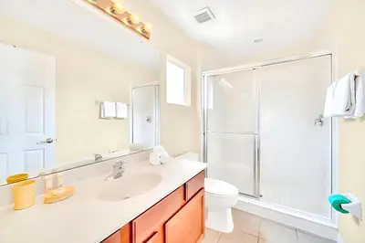 a white bathroom with a sink and a shower at Bella Vida House with Pool and Games - Near Disney! in Kissimmee