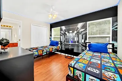 a bedroom with two beds and a desk at Bella Vida House with Pool and Games - Near Disney! in Kissimmee