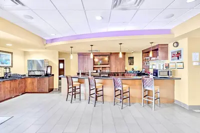 a large kitchen with a bar with stools at 1BR Apartment Close to Disney w Pool and Hot Tub in Orlando