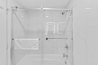 a bathroom with a shower with a glass door at Apartamento Moderno 2 Quartos The Enclave in Orlando
