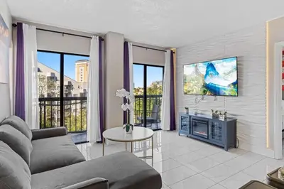 a living room with a couch and a tv at Apartamento Moderno 2 Quartos The Enclave in Orlando