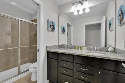 a bathroom with two sinks and a shower and a toilet at Neverland Nook in Orlando