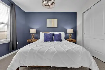 a blue bedroom with a large bed with blue walls at Neverland Nook in Orlando