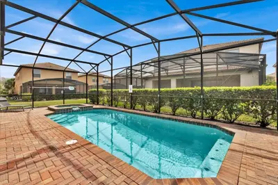 a swimming pool with a pergola next to a house at Neverland Nook in Orlando
