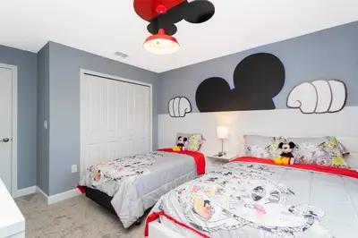two beds in a bedroom with blue walls at Townhouse Moderna 4Q c/ Piscina /10 Min da Disney! in Kissimmee