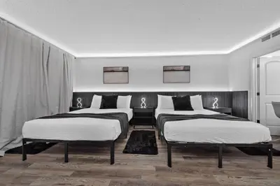 two beds in a room with white and black at Estúdio The Enclave – Piscinas, academia e vista in Orlando