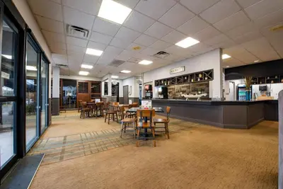 a restaurant with tables and chairs and a counter at Estúdio The Enclave – Piscinas, academia e vista in Orlando