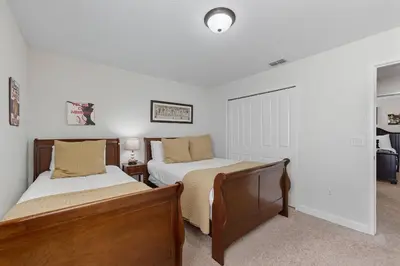 two beds in a bedroom with white walls at Vila 6 Quartos Storey Lake com Piscina & Spa in Kissimmee