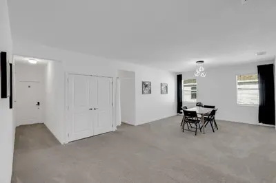 a living room with a table and chairs in it at Cozy Rooms In An Elegant House in Kissimmee