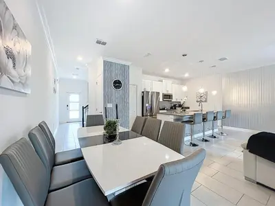a kitchen and dining room with a white table and chairs at Luxury Pool Home Near Disney Resort Access in Kissimmee
