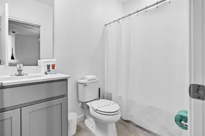 a white bathroom with a toilet and a shower at 2026 Luxury 5Bedrooms At Paradiso Grande in Orlando