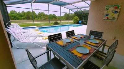 a patio with a table and chairs and a swimming pool at Magnificent View-Close to Disney in Kissimmee