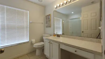 a bathroom with a sink and a toilet and a mirror at Magnificent View-Close to Disney in Kissimmee