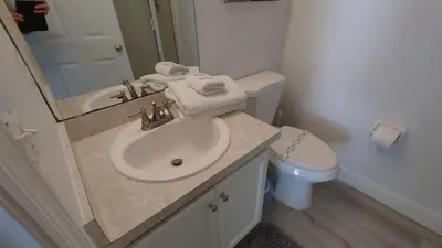 a bathroom with a sink and a toilet and a mirror at Magnificent View-Close to Disney in Kissimmee