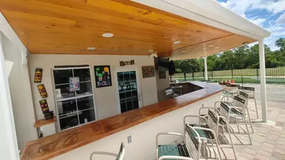 a bar with chairs on a patio with a wooden ceiling at Magnificent View-Close to Disney in Kissimmee