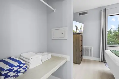 a room with white walls and a bench with towels at Orlando 2BR Apt Full Kitchen Epic Universe in Orlando