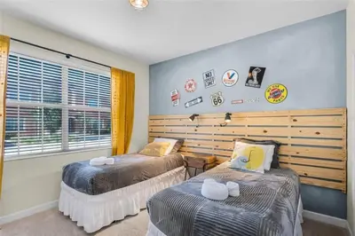a bedroom with two twin beds and a window at Luxury Pool Home Near Disney Resort Amenities in Kissimmee
